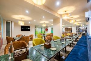 a restaurant with tables and chairs and a bar at Saltstayz Select- Medicity Near Medanta Hospital in Gurgaon