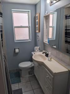 a bathroom with a sink and a toilet and a window at Private Room In Central Hamilton 2 in Hamilton