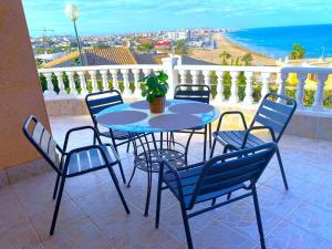 a table and chairs on a balcony with a view of the ocean at Chalet a orillas del mar in Torrevieja +39 photos