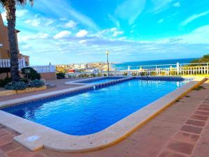 a large blue swimming pool on top of a building at Chalet a orillas del mar in Torrevieja