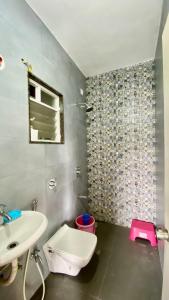 ein Badezimmer mit weißer Toilette und Waschbecken in der Unterkunft Go-Kul Home Stay in Kolhapur + 6 Fotos