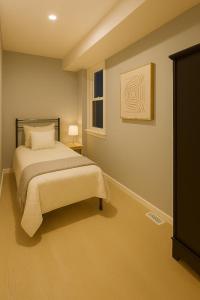 Un dormitorio con una cama y un cuadro en la pared. en Beautify Fully Equiped Unit, 5 minutes from the Arch, en Saint Louis