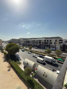 een straat met auto's en vrachtwagens op een parkeerplaats bij Nuchiii Hostel in Dubai