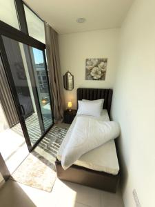 een slaapkamer met een bed en een balkon bij Nuchiii Hostel in Dubai