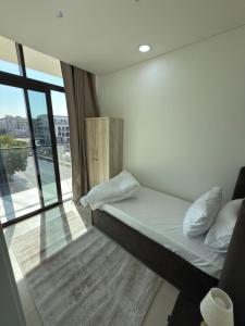 een klein bed in een kamer met een raam bij Nuchiii Hostel in Dubai