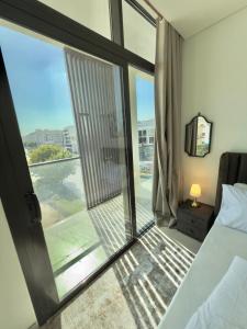 een slaapkamer met een bed en een glazen schuifdeur bij Nuchiii Hostel in Dubai