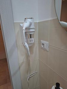 asciugacapelli appeso a un muro in bagno di Sant Antioco Yellow Apartment with 2 Way Air Con a SantʼAntìoco Altre 76 foto