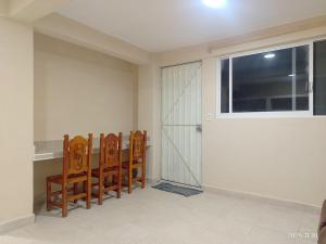 a dining room with four chairs and a window at Apartamentos Turiksa in Acapulco
