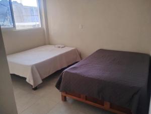 a bedroom with two beds and a window at Apartamentos Turiksa in Acapulco