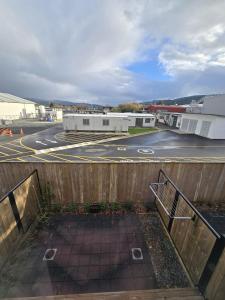 ein leerer Parkplatz mit einem Zaun und einer Straße in der Unterkunft Charming 3 Bedroom Home in Upper Hutt, Perfect for Families and Groups in Wallaceville