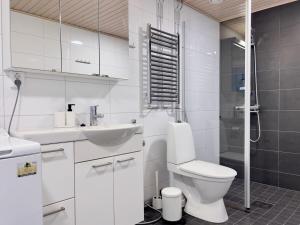 een witte badkamer met een toilet en een wastafel bij Modern Airport Apartment in Vantaa