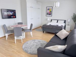 een woonkamer met een bank en een bed bij Modern Airport Apartment in Vantaa