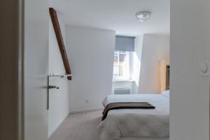 コルマールにあるLes Hauts de Colmarの白いベッドルーム(ベッド1台、窓付)