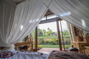 a bedroom with a bed and a large window at Serenity Villa & Spa in Ubud +110 photos