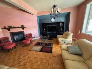 a living room with a couch and chairs and a fireplace at Pearson Gateway Comfort Home in Mississauga