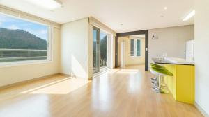 una cucina vuota con un'isola gialla in una stanza con grandi finestre di Gapyeong Applerotgi Pension a Gapyeong