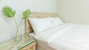 una camera con un letto bianco e una pianta su un tavolo di Gapyeong Applerotgi Pension a Gapyeong Altre 4 foto