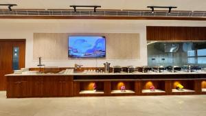 een grote keuken met een tv aan de muur bij Le OVAL Hotel & Resorts in Nakraunda