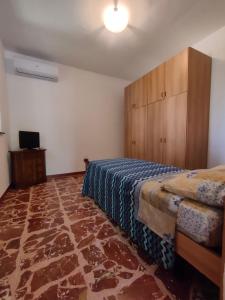ein Schlafzimmer mit einem Bett, einem Schrank und einem TV in der Unterkunft La Casa del Fungo in Montalto Uffugo + 36 Fotos