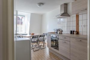 コルマールにあるLes Hauts de Colmarの白いキャビネット、テーブルと椅子付きのキッチンが備わります。