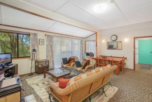 een woonkamer met meubilair en een flatscreen-tv bij 3 Barragoot Street in Bermagui