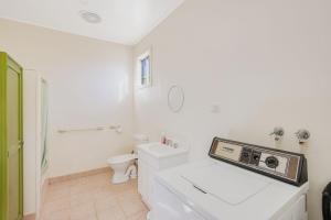 een witte badkamer met een toilet en een wastafel bij 3 Barragoot Street in Bermagui +10 foto's
