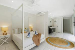 a white bedroom with a white bed and a bathroom at Belle Escapes Sandcastles in Palm Cove +49 photos