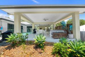 a covered patio with a table and chairs at Belle Escapes Sandcastles in Palm Cove