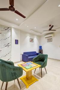 a living room with a blue couch and two chairs at Qotel Comfort Ashok Vihar in New Delhi