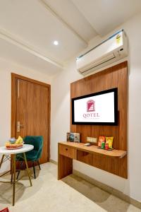 a room with a tv and a table and a chair at Qotel Comfort Ashok Vihar in New Delhi +68 photos