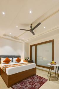 a bedroom with a bed and a ceiling fan at Qotel Comfort Ashok Vihar in New Delhi