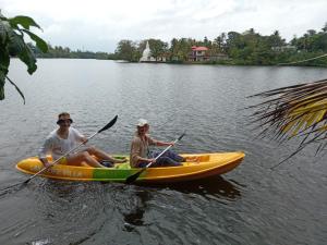 two men in a yellow kayak on a lake at Lake Life Villa in Ambalangoda