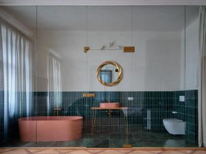 a bathroom with a tub and a sink and a mirror at donebe boutique hotel & private wellness in Kutná Hora