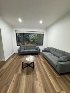 ein Wohnzimmer mit zwei Sofas und einem Couchtisch in der Unterkunft HOME away from HOME in Sydney