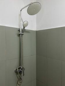 a shower with a shower head in a bathroom at Vibra Hostel in Sigiriya +36 photos