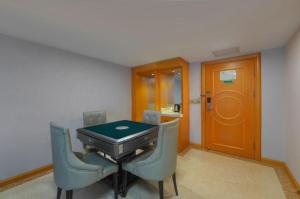 a room with a table with two chairs and a door at Vienna Hotel Guiyang North Station Dream City in Guiyang