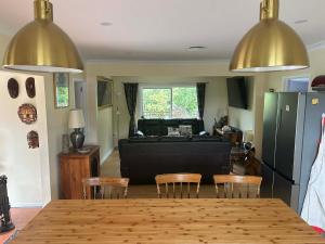 a kitchen and living room with a table and chairs at Beachy Sounds House in Carters Beach