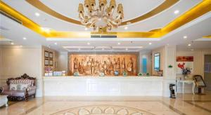 a living room with a chandelier and a large wall at Vienna Hotel Tianjin Zhongbei Town in Tianjin