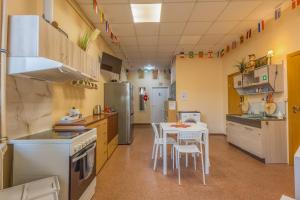 a kitchen with a table and chairs in it at Kaunas Center Hostel - Self-Check In in Kaunas +8 photos
