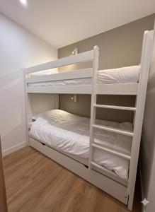 a bedroom with bunk beds with white shelves at Appartement rénové à Méribel Centre, avec Balcon et à 5 minutes des pistes et du centre in Méribel +18 photos