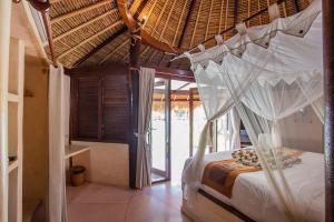 a bedroom with a bed with a canopy at Sanghyang Bay Villas in Nusa Lembongan +113 photos