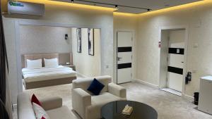 フェルガナにあるOhu Palace Hotelのベッドとリビングルームがあるホテルの部屋