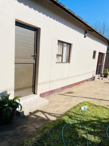 a white house with a garage door on it at Starlight bed and breakfast in Katima Mulilo