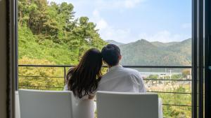 a couple looking out of a window at the mountains at Gapyeong Rubino Pension in Gapyeong