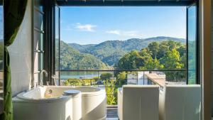 a bathroom with a tub and a large window at Gapyeong Rubino Pension in Gapyeong