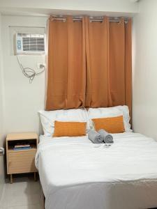 a bedroom with a bed with an orange curtain at 2BR Condo Near IT Park and Malls in Mandaue City
