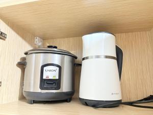 a slow cooker and a toaster sitting on a shelf at 2BR Condo Near IT Park and Malls in Mandaue City