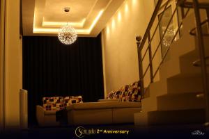 a living room with chairs and a chandelier at Hotel Senondra Ampara in Ampara