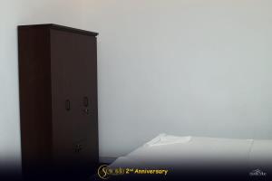 a white room with a cabinet and a bed at Hotel Senondra Ampara in Ampara