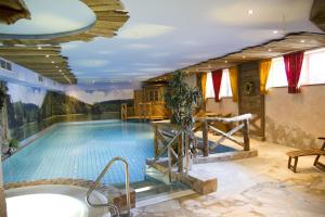 a large swimming pool with a tub in a room at Wellnesshotel Bürgerstuben in Willingen